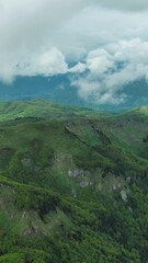 Wall Mural - aerial view of clouds over summer green mountains landscape, montenegro. vertical video