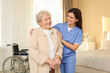 © New Africa - Smiling healthcare worker and elderly woman indoors