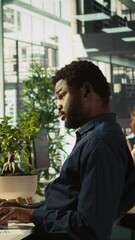 Poster - vertical video employee reviewing financial charts at desk in modern office, analyzing business perf