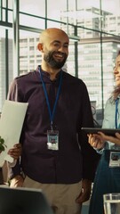 Poster - vertical video relaxed multiethnic coworkers in office having fun chatting while reviewing documents