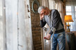 © NDABCREATIVITY - Old man with crutch feeling disappointed, lost in sad thoughts alone at home. Widow mature man.