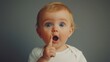 © ifoto - Baby with blue eyes, touching nose, wearing a white shirt.