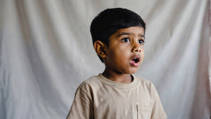 Poster - A young boy holds a toothbrush in his mouth, ready for brushing teeth