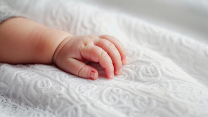 Aufkleber - Close-up view of a baby's tiny hand wrapped in a white blanket, perfect for tender moments and personal uses