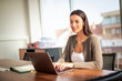 © gzorgz - Businesswoman sitting behind her latpop at office desk and working