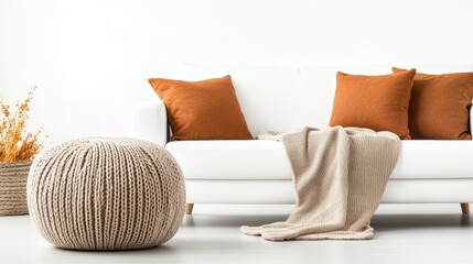 Poster - Beige knitted pouf in front of white sofa with burnt orange throw pillows and cream blanket alongside dried floral arrangement in woven basket