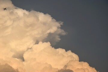 Wall Mural - plane flying throgh white and dark cloud floating on sky after rain falling in evening