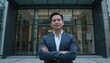 © Zabi - A professional man standing in front of a glass office building, arms crossed, confident facial expression, cinematic urban background