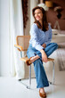 © sepy - Attractive brunette haired woman relaxing in a chair by the window