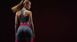 © Vasiliy - Athletic woman from behind in gray sports outfit with pink elements against dark background. Toned body with ponytail hair showing muscular back. Fitness concept for activewear promotion