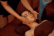 © InfiniteFlow - Caucasian woman enjoying relaxing anti-stress head massage and pampering facial beauty skin recreation leisure in warm candle lighting ambient salon spa in luxury resort or hotel. Quiescent