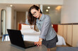 © Tommy - Professional woman using laptop at home or hotel, leaning forward and concentrating on screen.