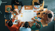 © InfiniteFlow - Top down aerial view of business team making scrum task board at meeting room. Group of people writing at paper and sticky notes for making kanban board to manage work flow. Top view. Convocation.