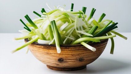 Aufkleber - Chopped green onions within a wooden bowl on a plain white surface.
