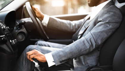 Poster - Closeup of black man in suit changing gears in car, entrepreneur driving auto