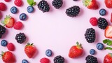 Various fresh colorful berries arranged on a pink background