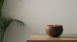 © Vitor - Uma configuração minimalista de uma vela de casca de coco em uma mesa de madeira, com espaço em branco para texto. Ideal para uso comercial em decoração de casa ou promoções de produtos de relaxamente
