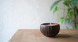© Vitor - Uma configuração minimalista de uma vela de casca de coco em uma mesa de madeira, com espaço em branco para texto. Ideal para uso comercial em decoração de casa ou promoções de produtos de relaxamente