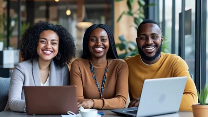 Poster - Three young professionals diverse ethnic backgrounds are working together laptops well-lit office. The team smiles directly camera creating warm , inviting atmosphere collaboration , success.