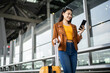 © Chanakon - Happy young asian woman traveler using smartphone and holding boarding pass while standing at the airport terminal ready for vacation trip, smiling female tourist with confidently travel insurance