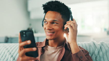 Poster - Headphones, phone and man on sofa in living room listening to music, album or playlist for review. Happy, relax and male person with cellphone and audio tech for streaming app with podcast in home.