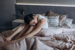 © kuzmichstudio - A beautiful brunette woman is resting on a bed in the bedroom