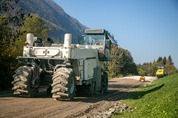 Fototapete - Gravel recycler at road construction site across nature landscape