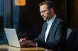 © shu - Successful mature businessman at work with laptop inside office, man in business suit sitting at desk typing on computer, satisfied with achievement result and work.