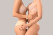 © Pixel-Shot - Beautiful young women in stylish beige underwear on grey background, closeup