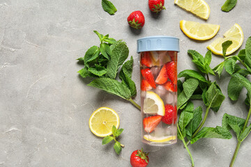 Wall Mural - Sports bottle of infused water with strawberries, lemon and mint on grey background