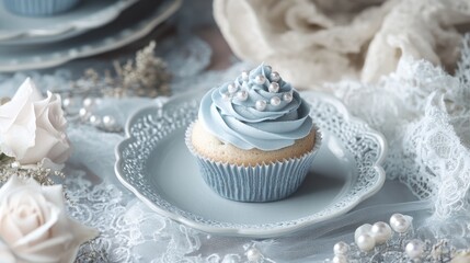 Poster - Beautifully decorated cupcakes with soft blue frosting and delicate edible pearls, placed on vintage lace, creating a refined and celebratory atmosphere.