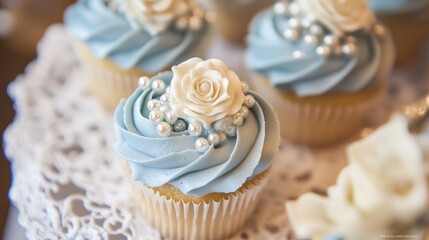 Poster - Beautifully decorated cupcakes with soft blue frosting and delicate edible pearls, placed on vintage lace, creating a refined and celebratory atmosphere.