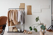 © Pixel-Shot - Interior of stylist's studio with clothes rack and palm plant
