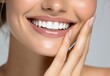 © Digital Dreamscapes - Woman's smile with perfect white teeth and hand near face against neutral background