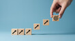 © StockWorld - Aim High, Achieve Goals: Step-by-Step Growth with Wooden Blocks & Target. Hand placing final block. Success, strategy, and ambition concept.