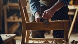 A carpenter constructing a wooden chair frame. Featuring skill and precision