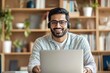 © Hasnah - Smiling man working from home on laptop with headset