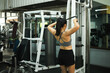 © saltdium - A Woman training at gym, performing cable face pulls to strengthen shoulders, upper back, and posture