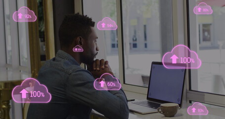 Poster - Image of pink clouds with rising numbers and businessman using laptop in office