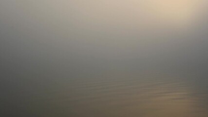 Wall Mural - Minimalist look into calm water morning shrouded in mist with warm pastel colors
