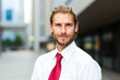 © Minerva Studio - Portrait of young businessman smiling in urban background