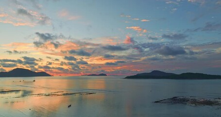 Wall Mural - aerial view of golden sky in sunrise over a fishing boat on the mud. scene of colorful golden sky in