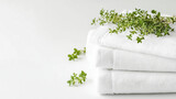 White spa towels with fresh green herbs on white background