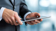© nur - Business professional using a tablet in a modern office setting with blurred background