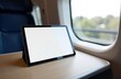 © YULIA - Tablet on train table with window view in modern passenger carriage