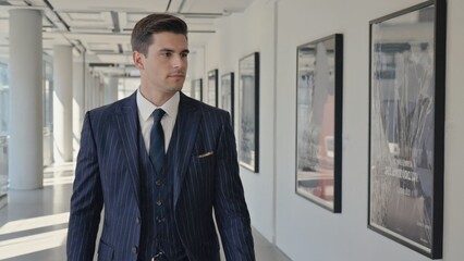 Poster - A businessman walks through a corporate hallway, possibly heading to a meeting or office