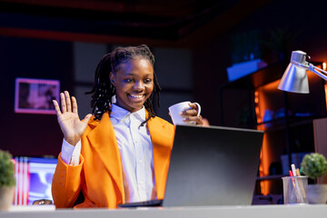 Poster - HR employee in home office at desk filming onboarding video, greeting job candidates. Woman holding coffee cup doing human relations job, recording video answering inquiries from employees