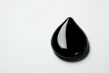 Poster - Glossy black droplet rests on matte white surface highlighting contrast and texture under high contrast lighting