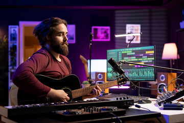 Fototapete - Musical composer singing tunes on acoustic instrument, working in his personal home studio to record a song. Sound engineer recording music, editing with mixing console. Acoustical engineering.