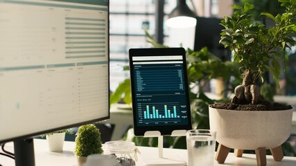 Poster - modern workspace with key performance indicators data on display in bright office environment with p